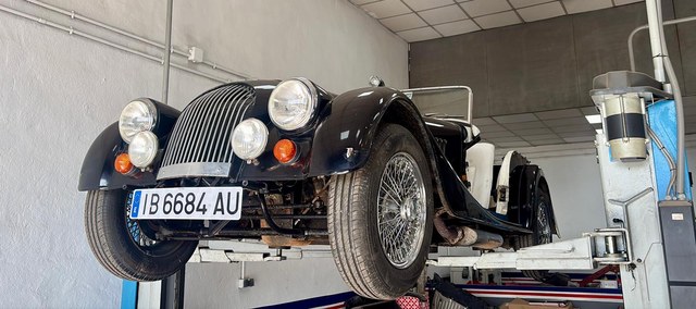 Coche clásico negro sobre el elevador